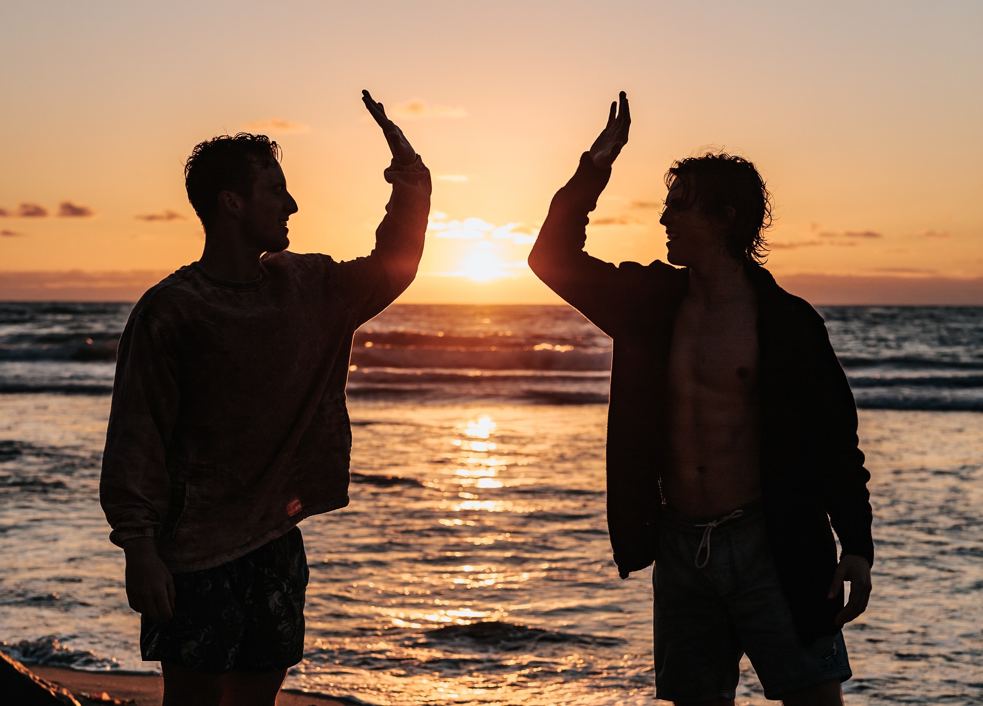 Silhouette of two people high-fiving